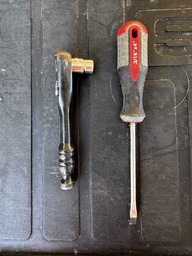 Tools needed to replace Subaru Outback liftgate struts, including socket, ratchet, and screwdriver